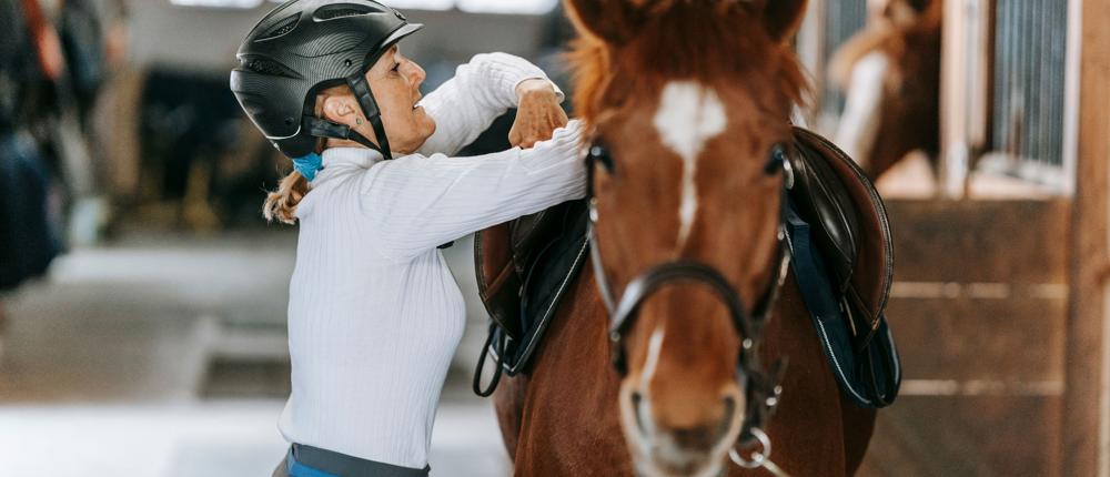 Lady Tacking Up A Horse