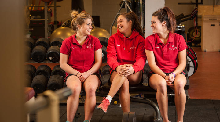 Women's Rugby College Students Sitting In Gym